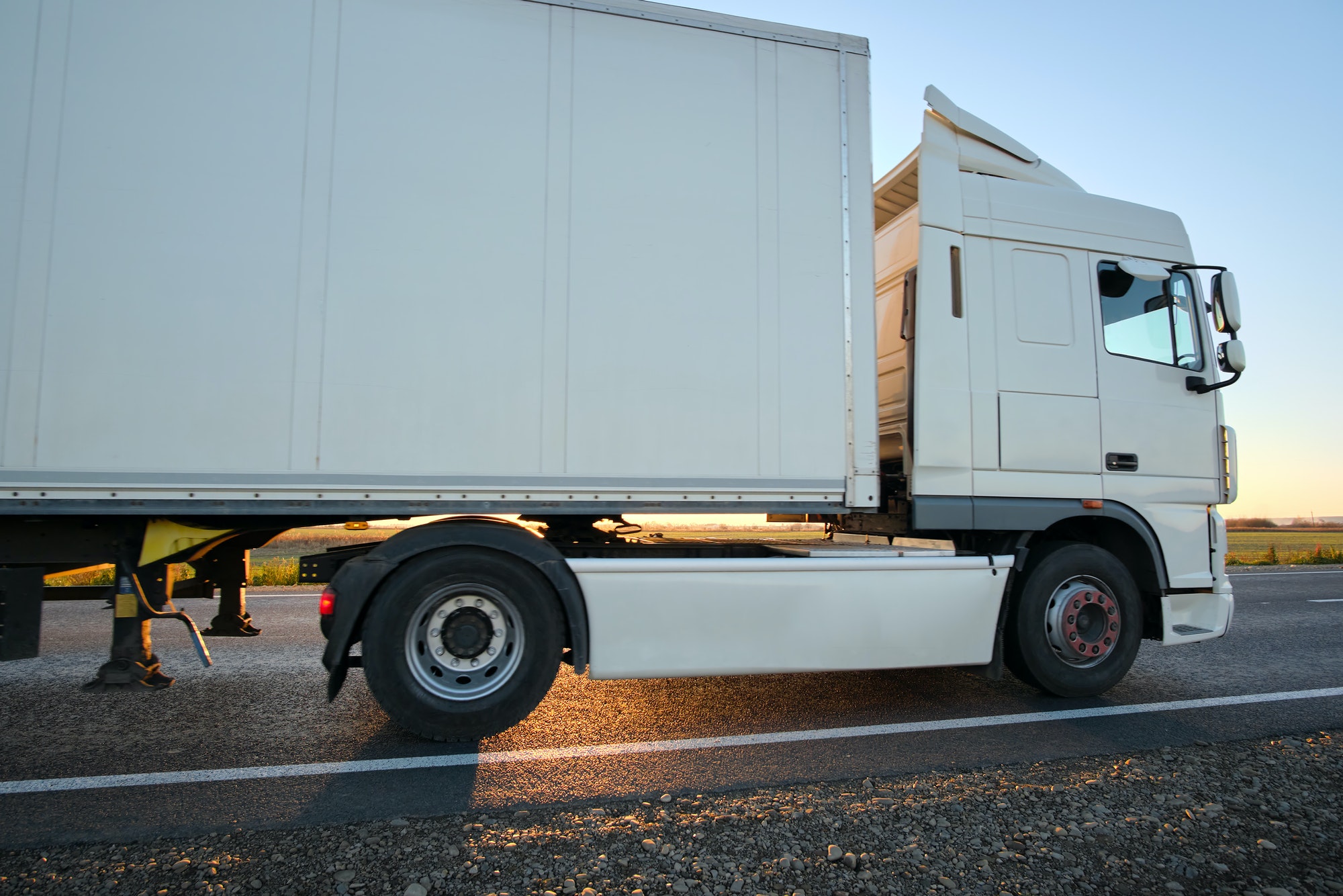 semi-truck-with-cargo-trailer-driving-on-highway-hauling-goods-in-evening-delivery-transportation.jpg